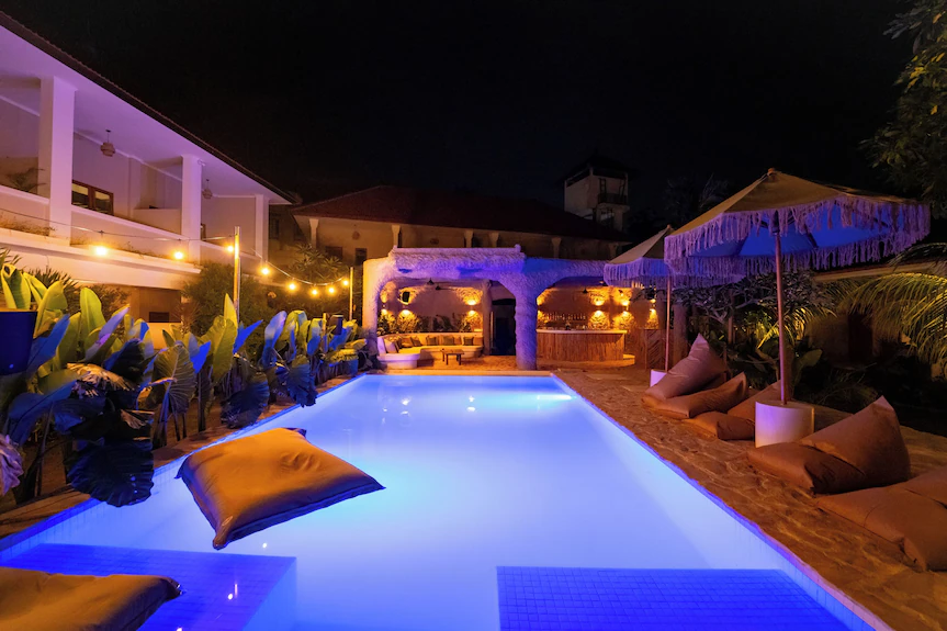 Mad Monkey night pool scene with blue lighting and bar - evening events and social atmosphere